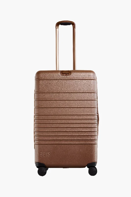 Vintage leather travel bag with brass accents for a classic and sophisticated lookThe Medium Check-In Roller in Maple