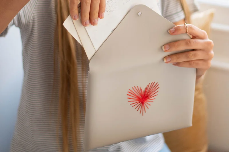 Laser - cut metal coin and key purses with geometric designsStitch Heart Strings Envelope Pouch